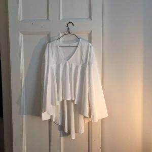  - Superfin fallande blus som är längre bak och kortare fram. Okänt märke inköpt utomlands. Okänt material men något glansigt. 