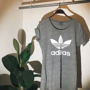  - Grå Adidas t-shirt med vitt tryck. Liten i storleken och har passat på mig som har medium! Aldrig använd. Fraktas för 40 kronor 😊