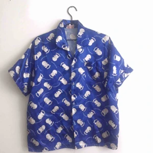  - Blå skjorta med Doraemon. Ingen storlek men skulle säga M.