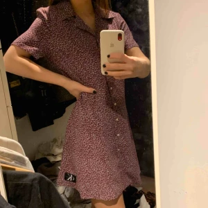  - Fin blommig samt mörkröd klänning från Calvin Klein, Klänningen är använd endast en gång då den inte är min stil o har fått den i present.. skulle föröver säga att den sitter som en S. Pristet kan diskuteras:)