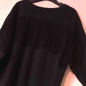  - Svart topp med fransar på ryggen. Aldrig använd. Lite oversize. Betala gärna med swish. Frakt blir 35 kr. Kan samfrakta om du köper flera varor av mig!