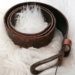  - Ett cognac färgat läderskärp från Pieces med nitar. Mycket bra skick. Enbart använt fåtal gånger. 
Frakt tillkommer. 