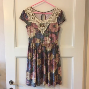  - Fin blommig klänning med virkat spetskrage. Väldigt mjuk och skönt material och perfekt för sommaren.