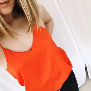 Topp med smala axelband från H&M. Färgen är stark orange vilket passar snyggt till slitna jeans!   Möts i Stockholm eller frakt 29kr