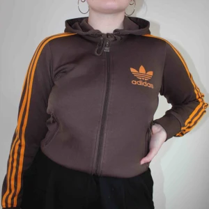  - Brun adidasjacka med fickor med dragkedjor. Skulle nog säga att den passar mer en 34/36 än en 38 