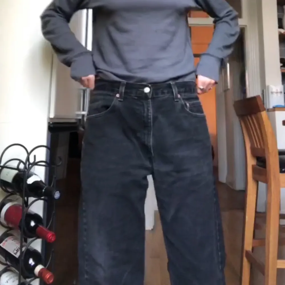 Svarta, äkta Levis-jeans som sitter jättefint på och är väldigt sköna. Lite balloon/boyfriend modell, men midjan är ganska liten i storleken. Den nedre delen av byxorna är upprullad.. Jeans & Byxor.
