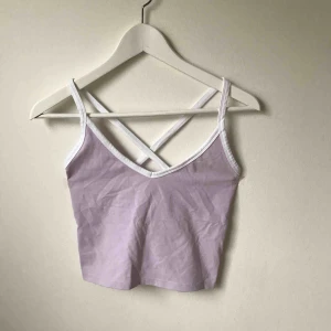  - Ljuslila och vit kort topp med kryssrygg. Använd 1 gång. Köparen står för fraktkostnad enligt postens portotabell.