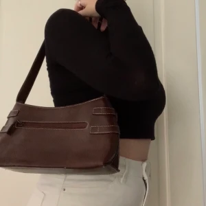 snygg väska - snygg shoulderbag i läderimitation! På framsidan så finns det dock hål från gamla stygn (se bild 3) därav det billigare priset, men den är i bra skick utöver det och är snygg att ha på andra hållet! köparen står för frakten💕🦋