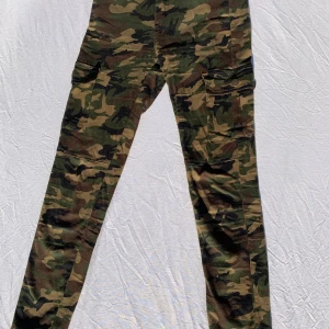 Camoflage Nina Carter i storlek 38 - Ett par väldigt coola jeans med häftiga detaljer som två fickor på benen. Byxorna är i storleken 38 men eftersom de är relativt små skulle säga att dem passar någon i storlek 36.