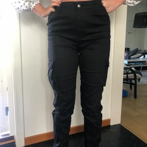 Cargobyxor - Svarta cargobyxor, muddar ner till, inga fickor bak, fickor på benen, mycket bra skick, endast använda 1 gång, kommer ej till användning, sitter mycket bra, frakt: 60 kr