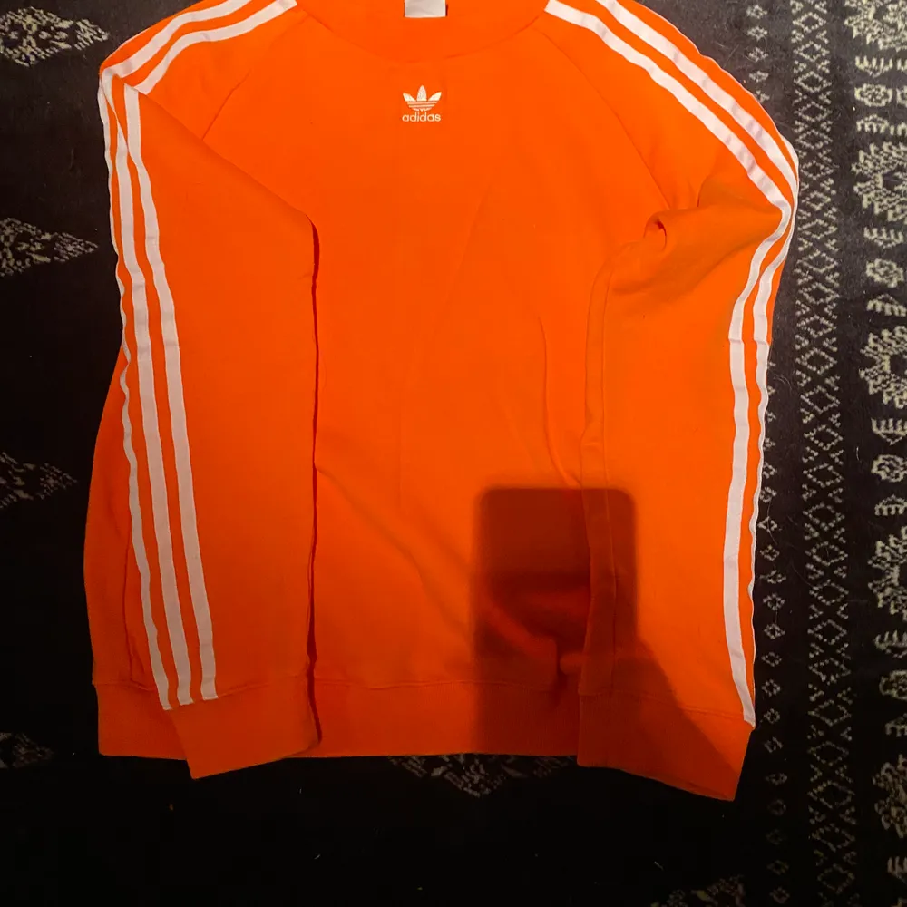 Skitsnygg orange adidas tröja, köpt från jd sports. Använd fåtal gånger.. Hoodies.