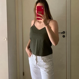 Grönt linne  - Grönt linne i linnetyg, enkelt och snygg med lite silver detaljer på axelbanden. Helt oanvänd och i nyskick 