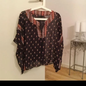  - En fin blus från Mango i transparent tyg med mönster och snörning framtill. Luftig och skön till sommaren. 