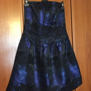  - Blå/svart festklänning från H&M i Strl 44.  Helt oanvänd, prislapp och band sitter kvar, fickor finns också.  Ni står för frakten om vi inte möts upp. 