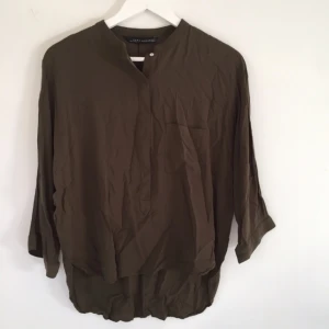  - Olivgrön mjuk blus med knappar och bröstficka, kort och vid modell. Passar som S. Kan posta eller mötas i Sthlm/Gbg