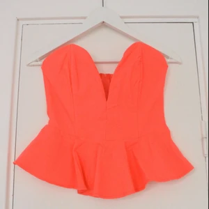  - Snygg korallfärgad peplumtopp med djup urringning och snygg passform. Aldrig använd!! 