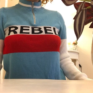 stickad polo med zipper  - Burit en gång, mjuk och multifärgad med REBEL tryck på, köpt från ASOS!