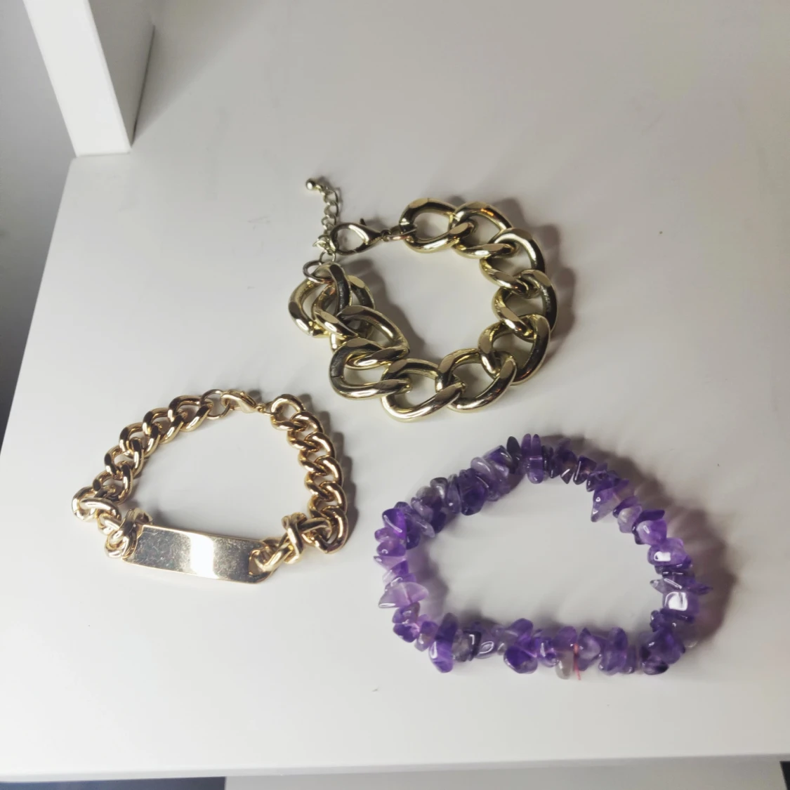 olika armband i guldfärg samt lila  - 91