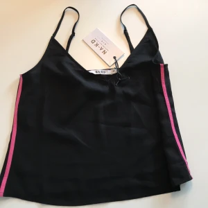 NA-KD linne  - Svart linne ifrån NA-KD med rosa sträck i sidorna. Storlek 34. Aldrig använd. Justerbara band. Skriv för fler bilder. Frakt tillkommer.