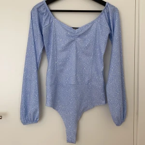 Bikbok body  - En blå body från Bikbok med vitt mönster. Använt en gång. Fraktkostnad tillkommer. Priset kan diskuteras.
