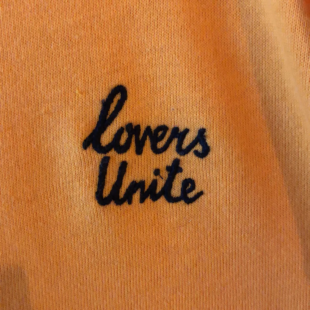 Gul/orange sweater från H&M (DIVIDE), svart insydd text ”lovers unite”. Storlek M. Tröjor & Koftor.