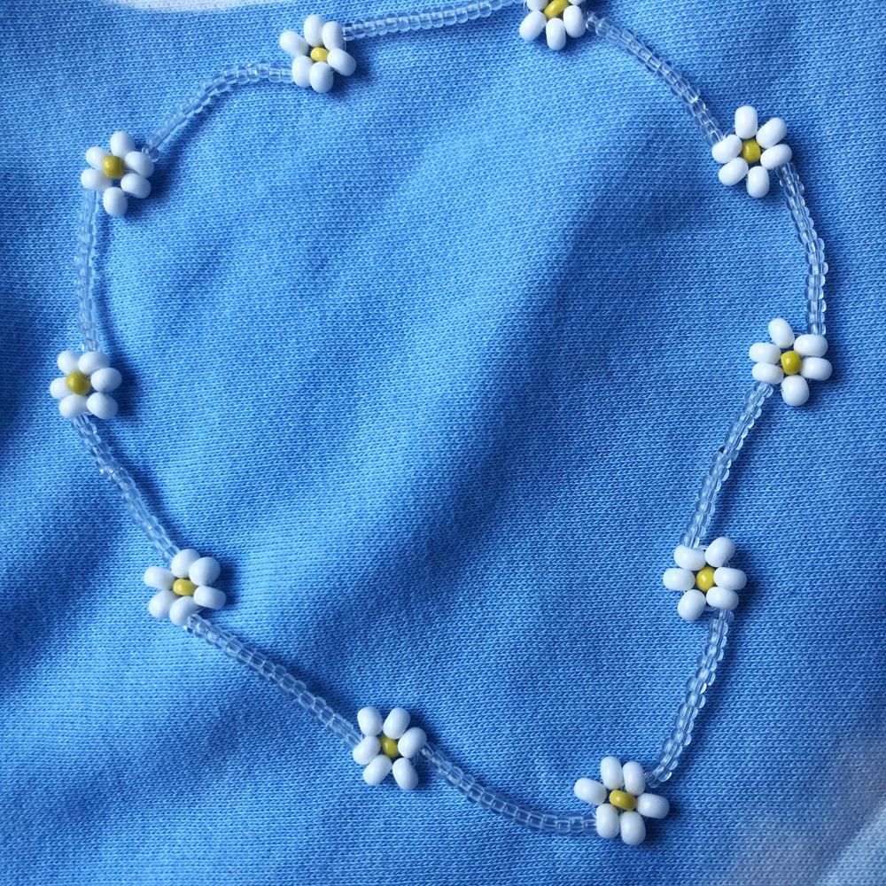 Ett pärlhalsband med vita blommor. Super fint till sommaren! Bra kvalitet och töjbar tråd. Skriv om du vill att jag ska göra halsbandet kortare/längre. 11 kr frakt☀️💕☀️💕. Accessoarer.