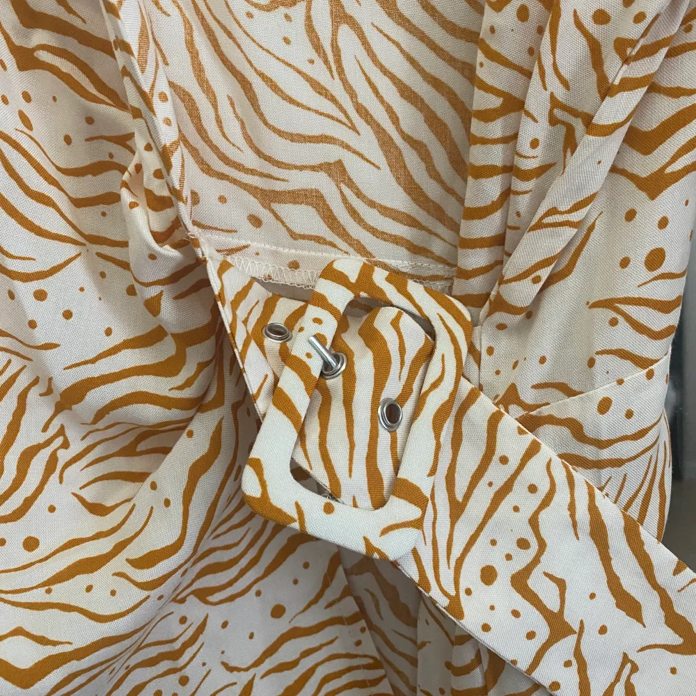 Em orange och vit zebrarandig blus från ASOS tall köpt i februari detta år. Endast provad , så därmed är den helt ny.  Blusen är i omlottmodell med bälte i midjan . Jag fraktar gärna plagget mot avgift :) . Blusar.
