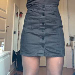 Svart kjol med knappar från Gina Tricot i storlek 36