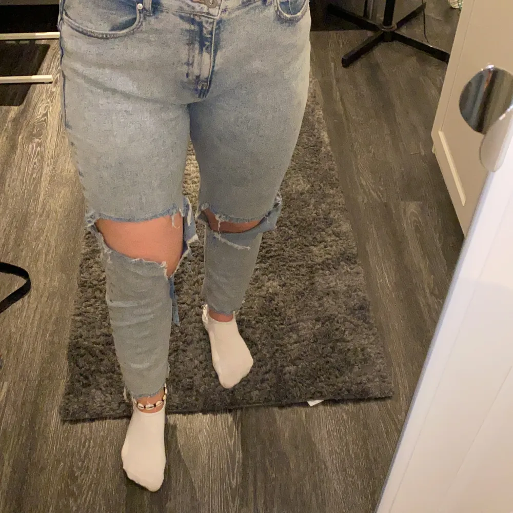 Blåa mom jeans med stora hål på knäna. Från reserved . Jeans & Byxor.