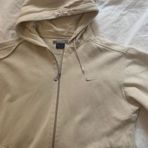 Nike hoddie - Super snygg och trendig beige Nike hoddie! Köpt secondhand men ser mycket äkta ut och är i perfekt skick. Passar S-L så den är rätt oversize på mig som vanligtvis bär S-M. Lägg ett bud i kommentarerna från 150kr (buda minst med 15kr). Buda inte om du inte vill köpa eller har pengarna!🥰  köpare står för frakt💓 KÖP DIREKT FÖR 400kr