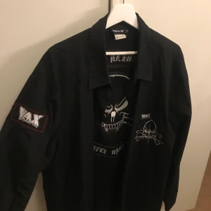 Skjorta med tryck - Svart skjorta med tryck både fram, på armen och bak. Från wax i strl XXL, men sitter mer som en XL