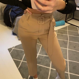 Beiga kostymbyxor med bälte från NA-KD  - Supersnygga beiga kostymbyxor med bälte från NAKD i storlek 34 💕 skriv till mig för fler bilder!!