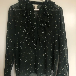Blus, H&M, Strl 36 - Jättefin blus från H&M i grön med prickar. Något genomskinlig. Volang framtill. Frakt: 48kr.