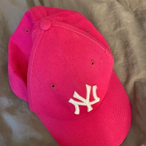 NY NEW ERA -NYSKICK KEPS! - Cerise och vit. Köpt o provad, men inte använd. Så inget slitage eller fläckar. Se bilder noga. Frakt 36:- tillkommer. Supercool!