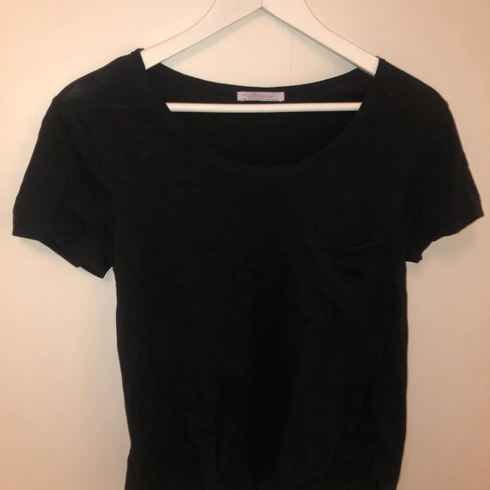 En enkel svart T-shirt från ZARA med en ficka ovanför vänster bröst. T-shirts.