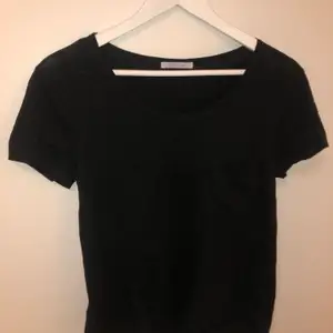 En enkel svart T-shirt från ZARA med en ficka ovanför vänster bröst