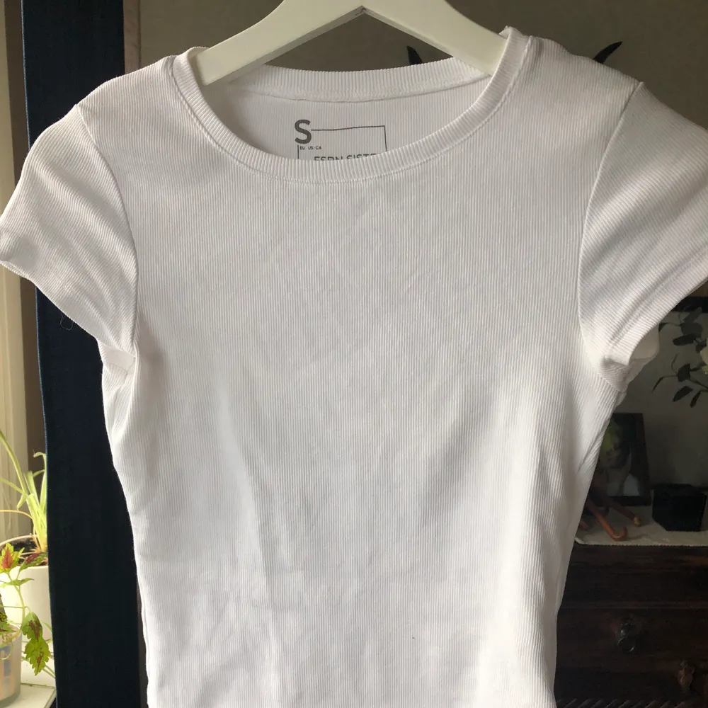 Ribbad vit T-shirt som sitter tajt på kroppen i storlek S✨Köparen står för frakten som är 48kr✨. T-shirts.