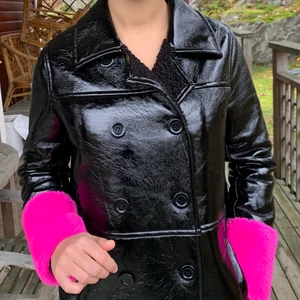 Glansig, cool kappa - Här har vi en fräck, glansig kappa från Stand som håller kylan ute. Den är fodrad inuti och går att knäppa hela vägen upp till kragen. Kappan är sparsamt använd och ser och känns helt ny. Jag som bär jackan på bilden är 170cm och den når precis under mina knän. Det står ingen storlek på jackan men jag skulle tippa på någonstans mellan storlek 36-38. Nypris är cirka 2800kr