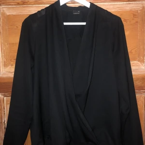 Omlott blus  - En svart långärmad omlott blus från ginatricot i fint skick! Använd ett fåtal gånger, fin passform men kommer inte till användning för mig längre. Köparen står för frakten och det angivna fraktpriset kan ändras! 