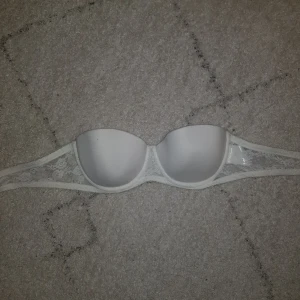 Strapless bh - En vit strapless bh från H&M. Aldrig använd. Perfekt när man bär en axellös topp eller klänning!