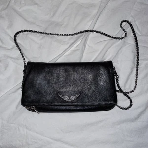 Zadig & Voltaire väska - Skinnväska från Zadig & Voltaire. Inköpt för ca 3 år sedan, men endast använd ca 1 år. Endast den långa kedjan medföljer!