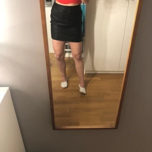 Svart skinnkjol - Jättefin svart skinnkjol som sitter uppe pga av att den är tight. Är stretchig dock så det är inte svårt att röra sig💕 säljer för att den är för stor för mig i midjan som syns på tredje bilden. Storlek S. Köpt på Nelly
