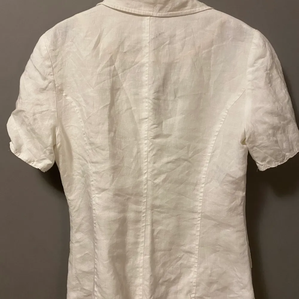 Säljer denna vita kortärmade skjortan, den knäppas av 3 knappar med en figurform . Skjortor.
