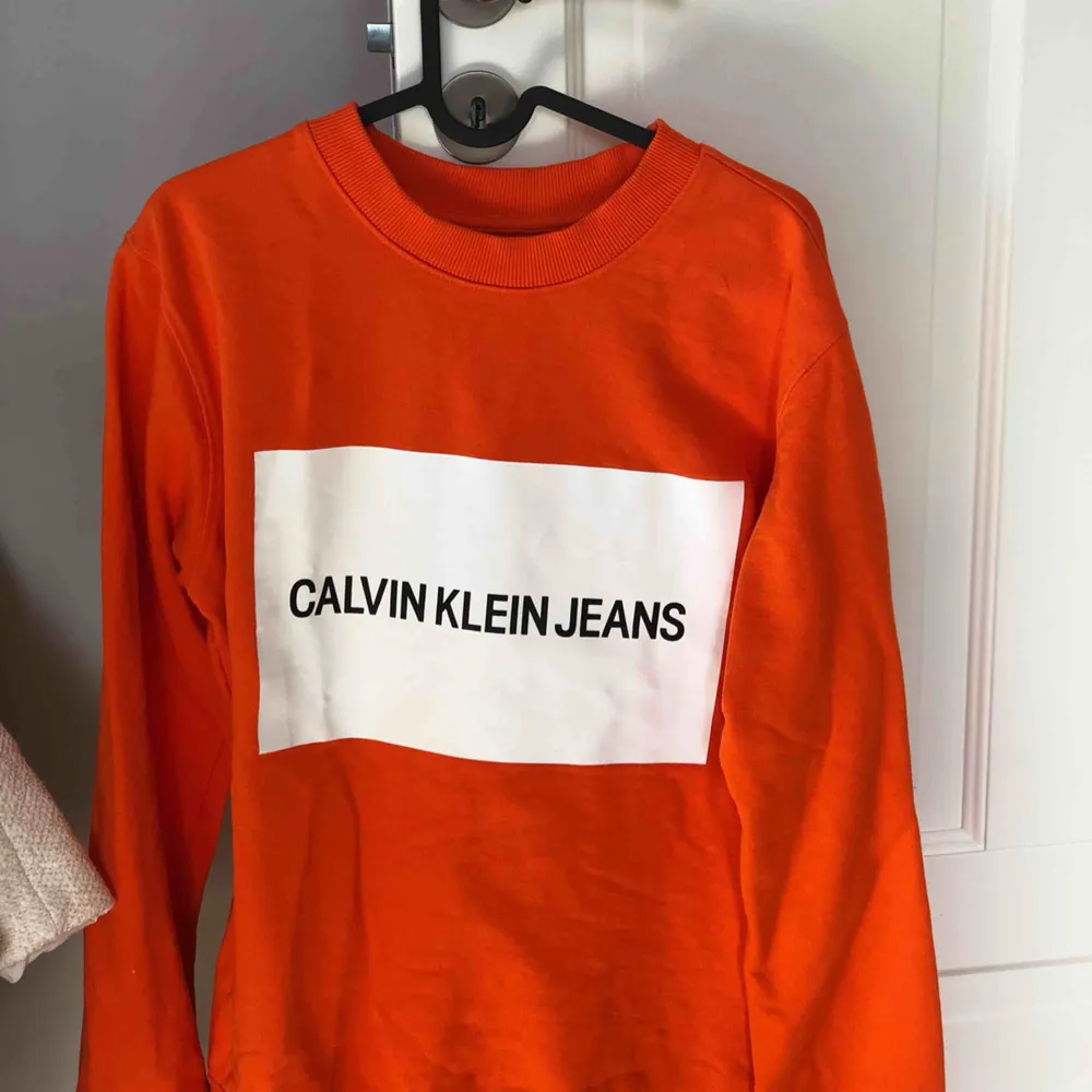 Orange Calvin Klein tröja, aldrig använd. Storlek M. Säljer den för att den inte riktigt är min stil. Säljs idag på Zarlando för 979 kr, men jag säljer den för 699. Köparen står för frakten.. Tröjor & Koftor.
