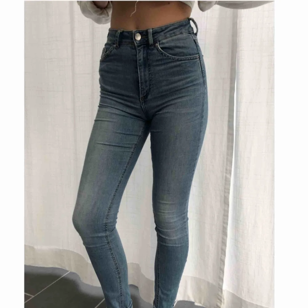 Tighta ljusblåa jeans från H&M med slitage på ena fickan. Använda några få gånger.. Jeans & Byxor.