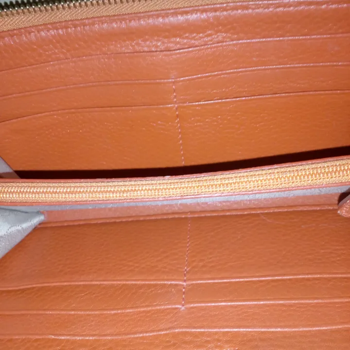 Orange plånbok i skinn fr Michael Kors, i mkt gott skick, inga fläckar eller andra skador förutom att märket är lite repigt, naturligtvis äkta!  Köparen betalar frakt 55kr. Väskor.