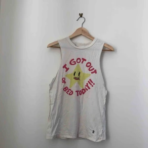  - Vit mucle-tee/linne, oldschool dropdead med motiv av en sol och texten ”i got out of bed today!!”  Kan mötas längst roslagsbanan eller i stockholm. Annars står köparen för frakt.