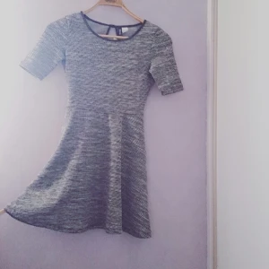  - Snygg skaterklänning i tweedliknande grått tyg från H&M. Kantband i läderimitation längs urringningen. Aldrig använd. 
