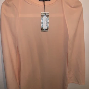 Rosa Cape Midi dress  - Klänningen är från Boohoo och har inte använts. Köpte klänningen för 1 år sedan och butiks lappen finns kvar. Jättefin att ha på sig på t.ex. bröllop eller om man ska ut och äta middag och vill vara finklädd. Den är slimmad.