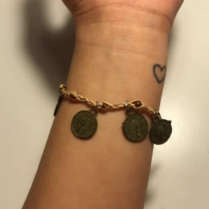 Armband - Vintage armband med mynt på och bandet är gjord av torkat gräs med gula stenar som innebär tur (luck). Frakt 11 kr